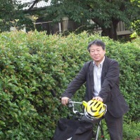 自転車活用推進研究会理事長の小林成基さん。愛車のブロンプトンとともに