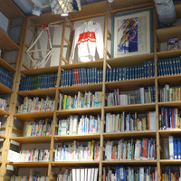 壁一面に並べられた自転車関連の書籍や雑誌。フロアにはクラシックな自転車や部品が展示されている