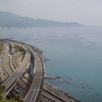 サッタ峠からうねる車道と駿河湾を見下ろす。富士山は霞んでいて見えない