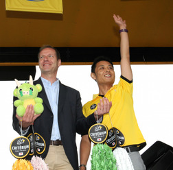 ツール・ド・フランス第3ステージのスタート地点で、さいたま市役所スポーツイベント課の清水大樹主任がクリスティアン・プリュドムに千羽鶴を贈呈した