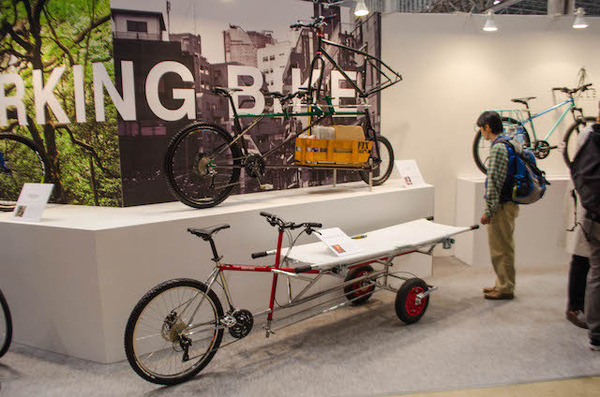 東京サイクルデザイン専門学校の展示に足を止める人（サイクルモード14）