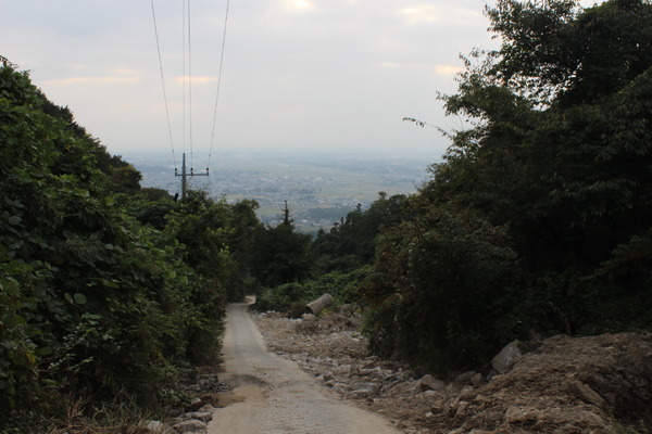 スタート地点の3号目まであと少し。道のむこうには田園風景が。通常の登山＋道迷いで疲れた心と身体を癒してくれる風景であった。