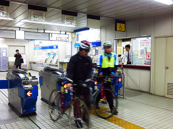 自転車を転がして千葉みなと駅の改札口を通る参加者たち（11月30日、千葉モノレール実証実験「サイクル＆モノレール」）