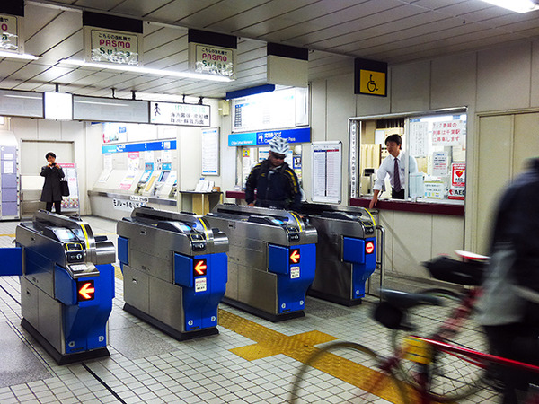 自転車を転がして千葉みなと駅の改札口を通る参加者たち（11月30日、千葉モノレール実証実験「サイクル＆モノレール」）