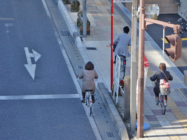 車道を逆走する自転車。通行区分違反によって交通切符が交付され、安全講習が課されることになる