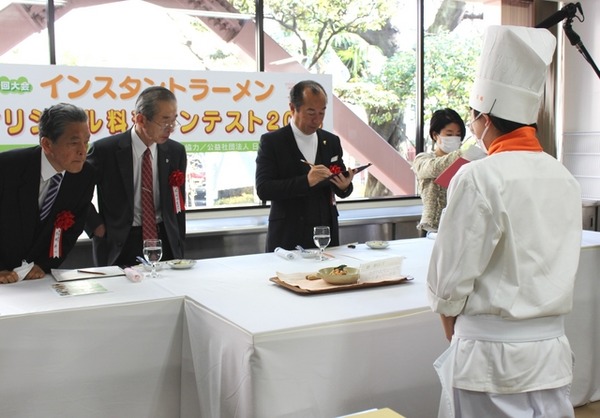 審査員たちが、学生がつくったラーメンを審査しているところ